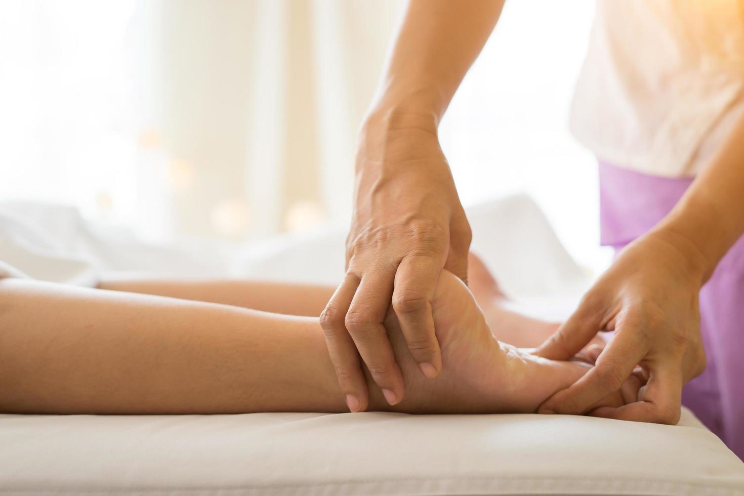 close-up de mulher fazendo massagem nos pés no spa foto