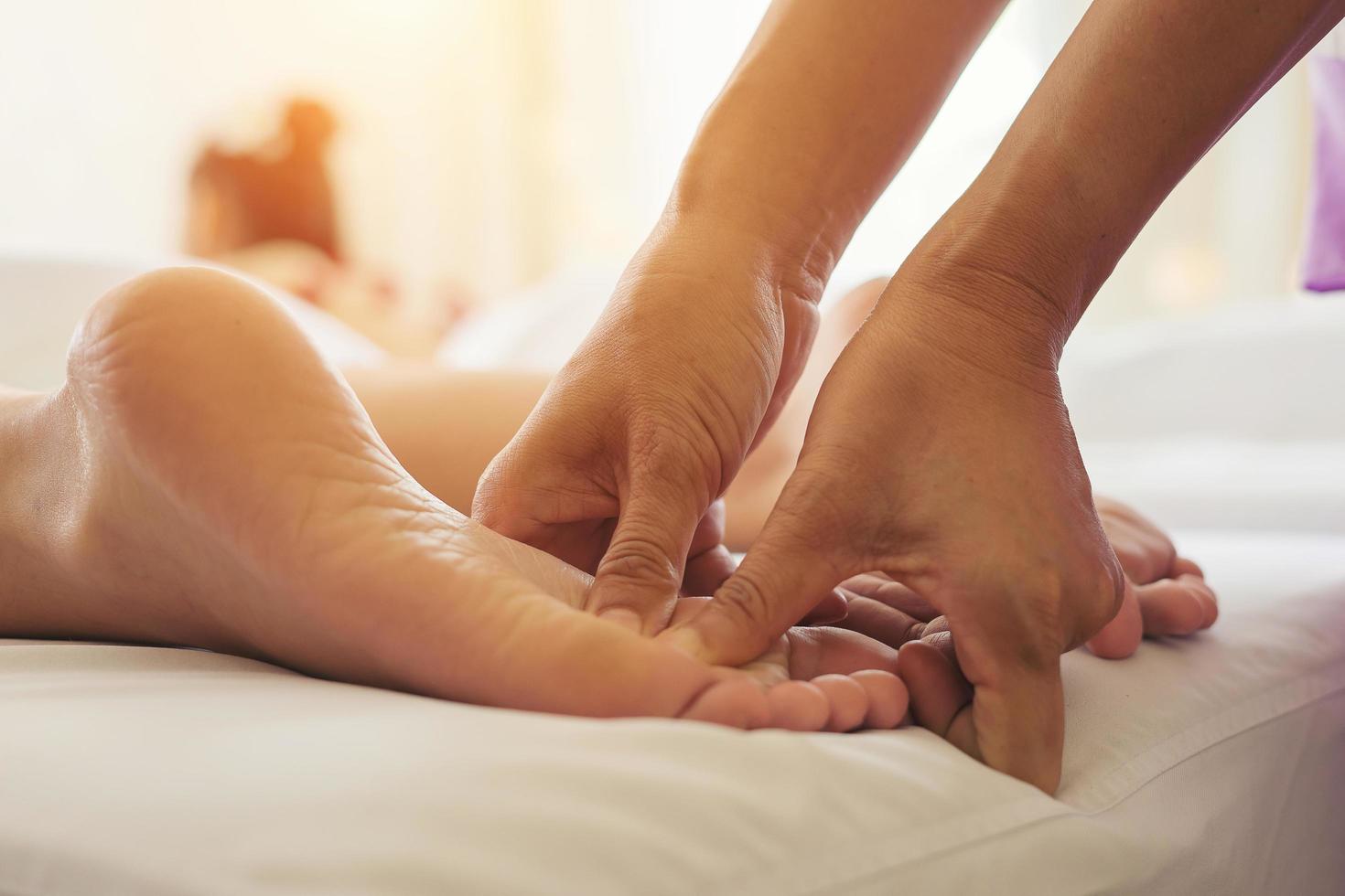 close-up de mulher fazendo massagem nos pés no spa foto
