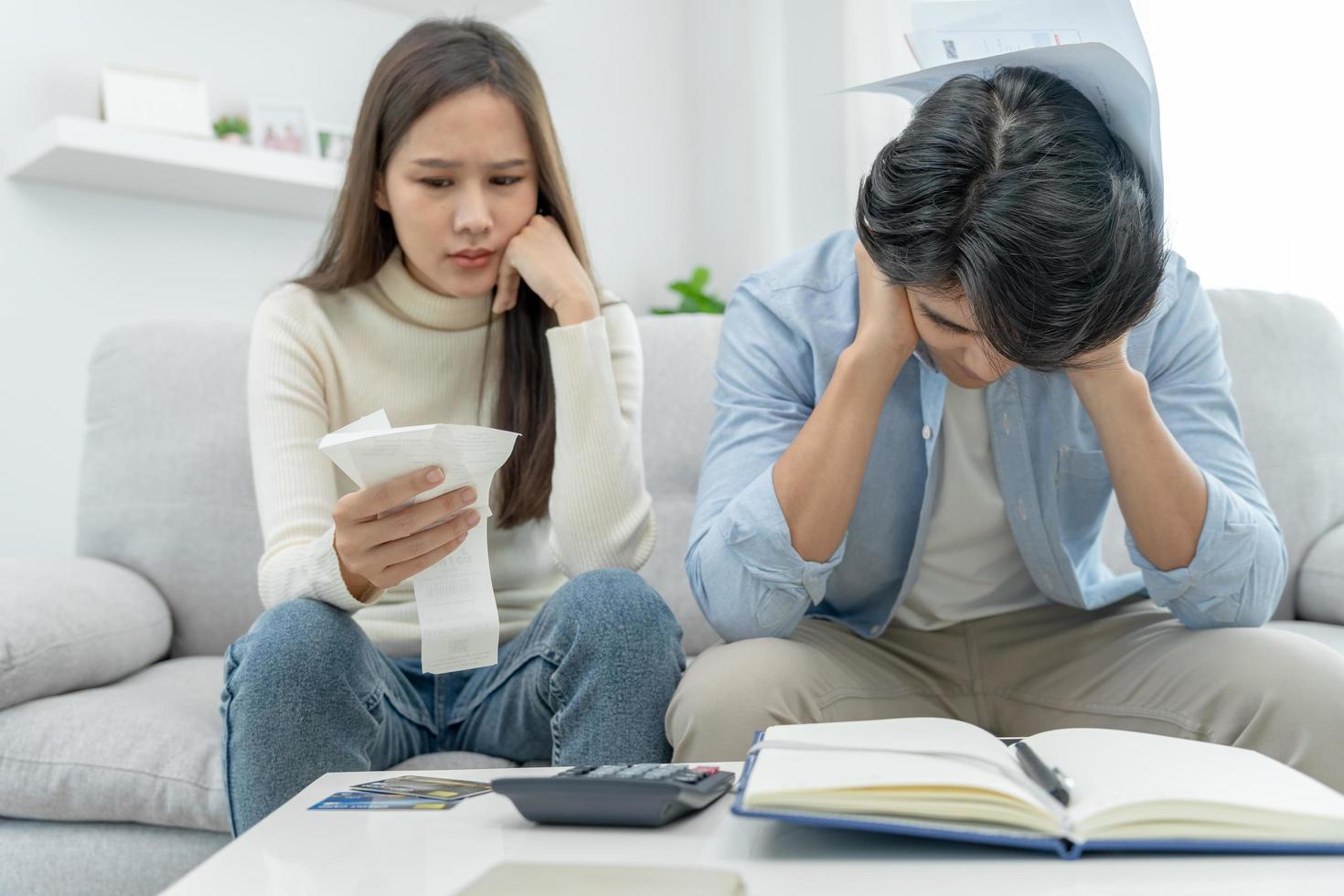 homem asiático estressado e com dor de cabeça com grandes contas ou faturas sem dinheiro para pagar despesas e dívidas de cartão de crédito. escassez, problemas financeiros, hipoteca, empréstimo, falência, falido, pobre, carteira vazia foto