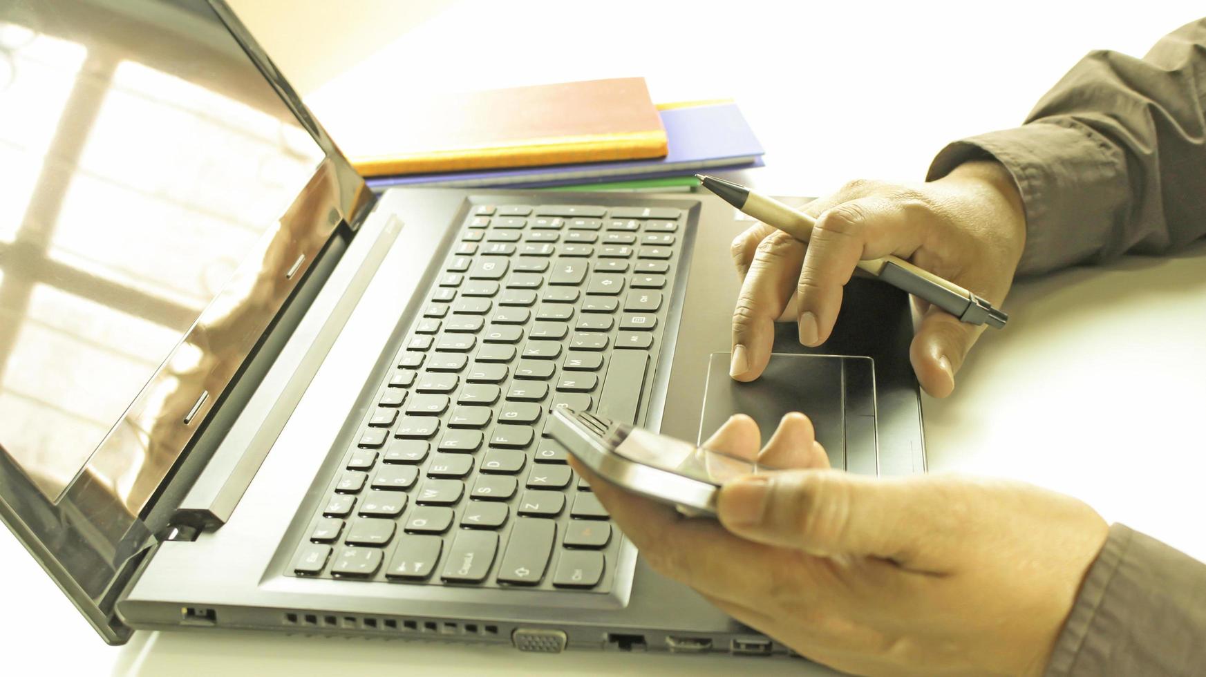 profissional trabalhando em laptop e telefone foto