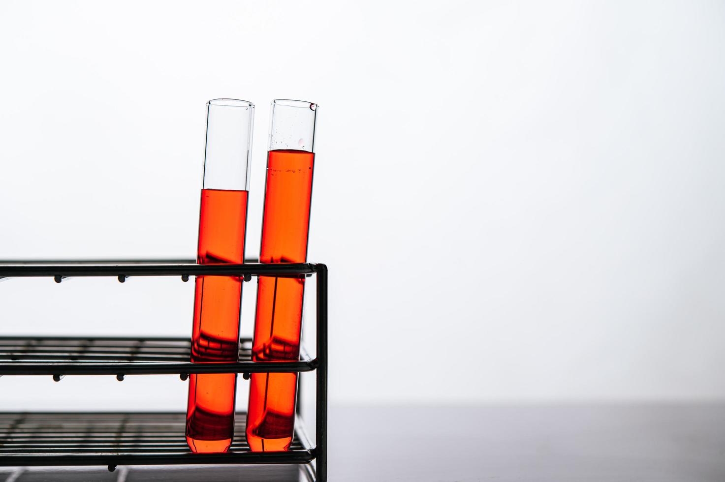 produtos químicos laranja em um tubo de vidro científico disposto em uma prateleira foto