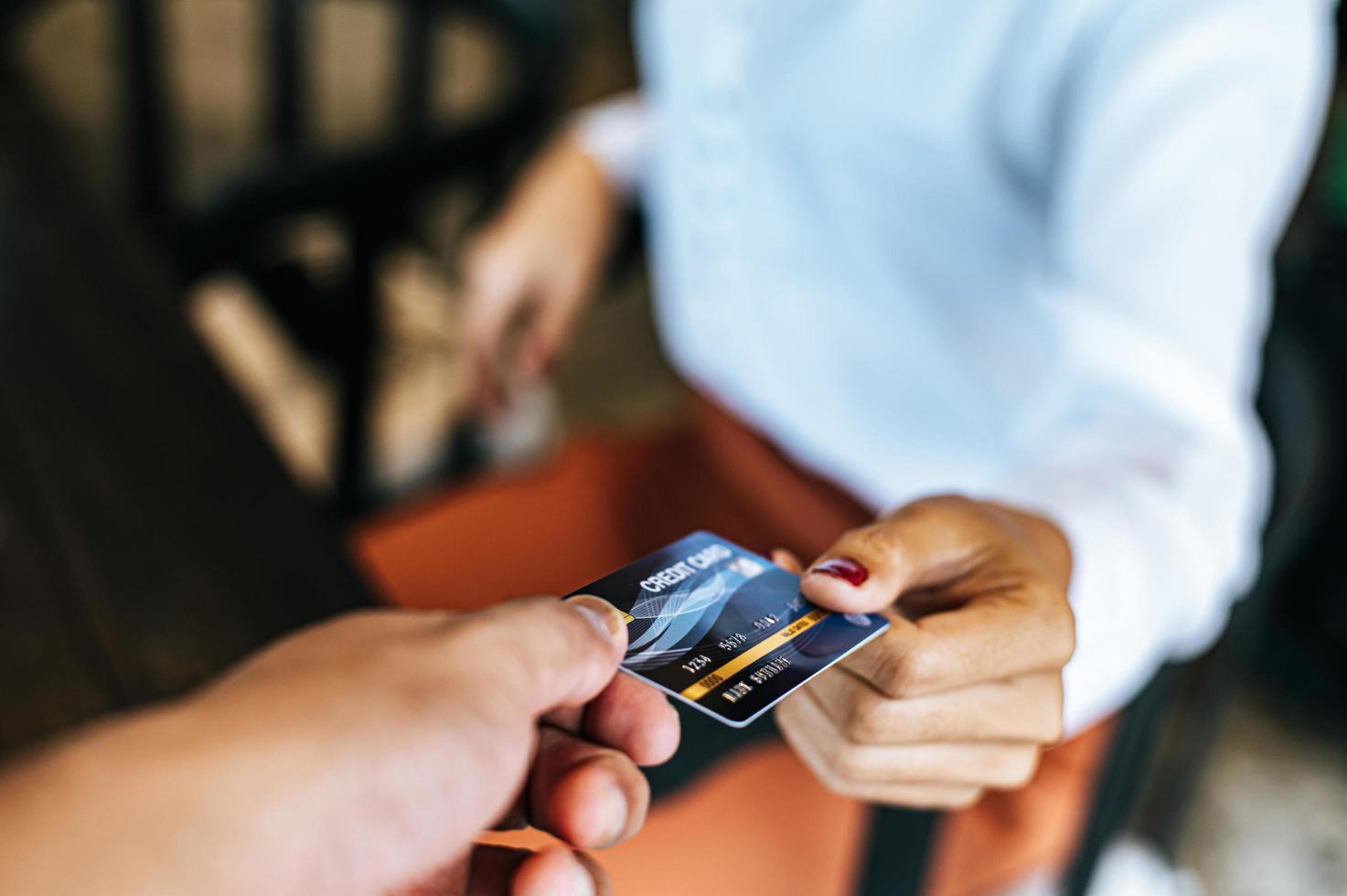 mulher enviando cartão de crédito para pagar mercadorias foto