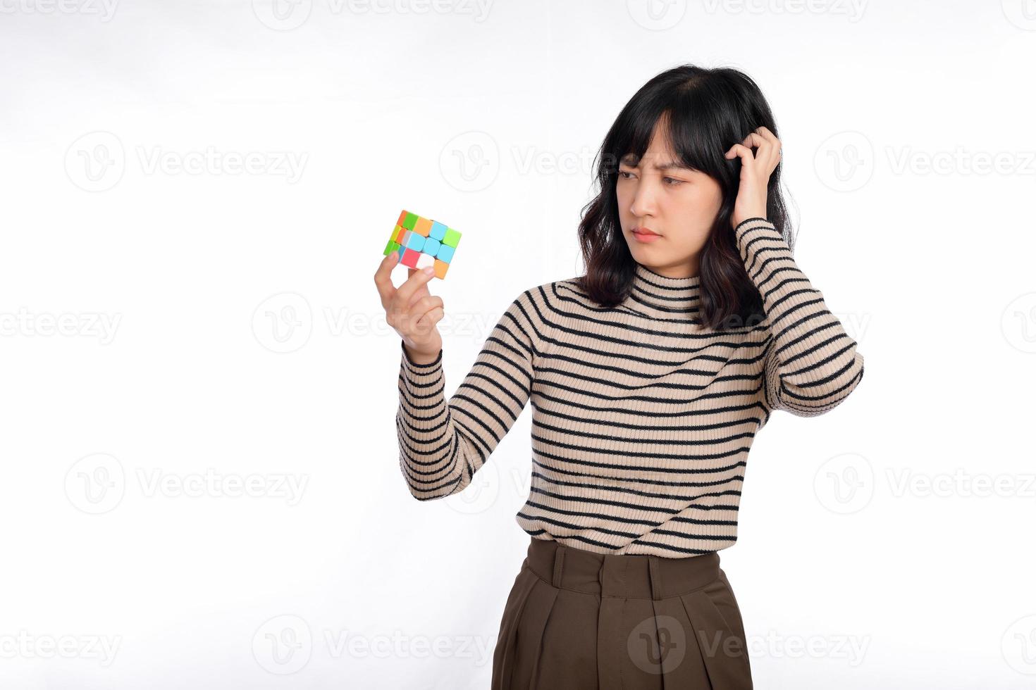 ásia mulher segurando uma rubik cubo em pé em branco fundo. resolução cúbico problemas, problema solução e fazer estratégico movimentos conceito foto