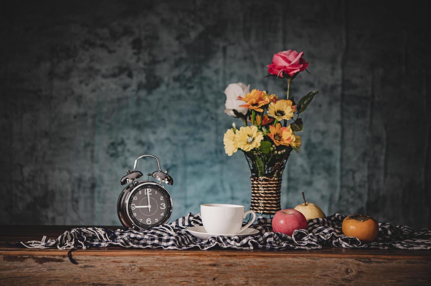 natureza morta com vasos, flores, frutas, xícaras de café e relógios foto