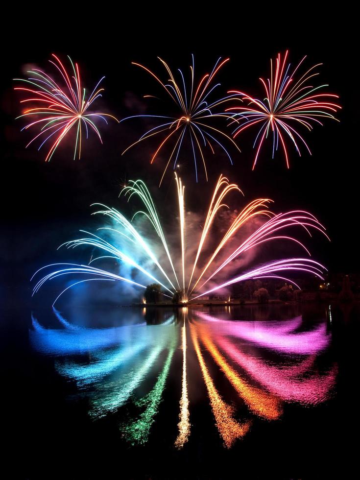 fogos de artifício coloridos refletidos em um lago foto