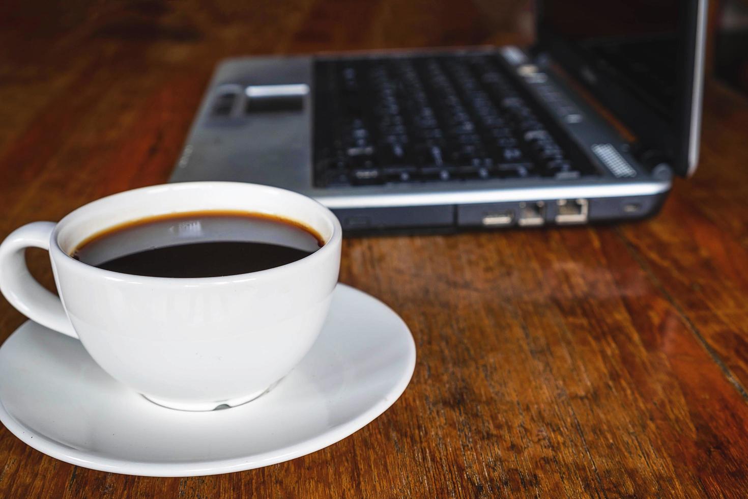 café e laptop em uma mesa foto