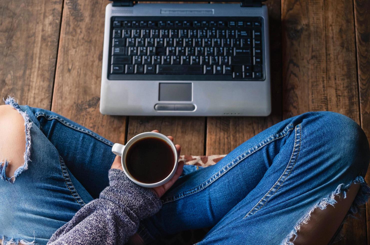 pessoa segurando um café com um laptop foto