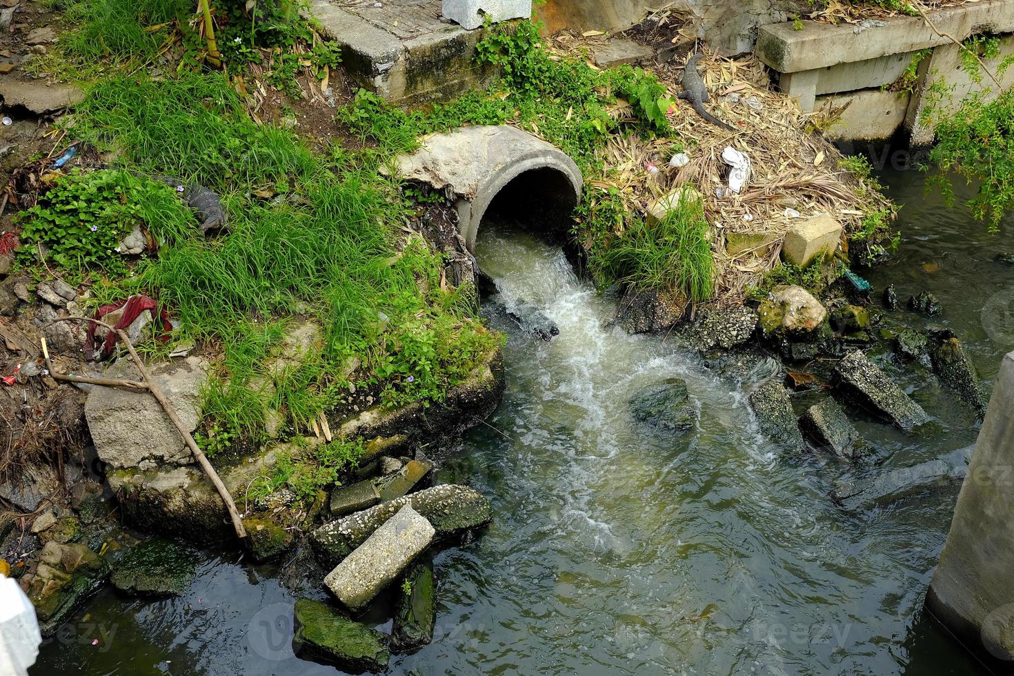 águas residuais fluxos a partir de esgoto para canal, de Meio Ambiente degradação conceito. foto