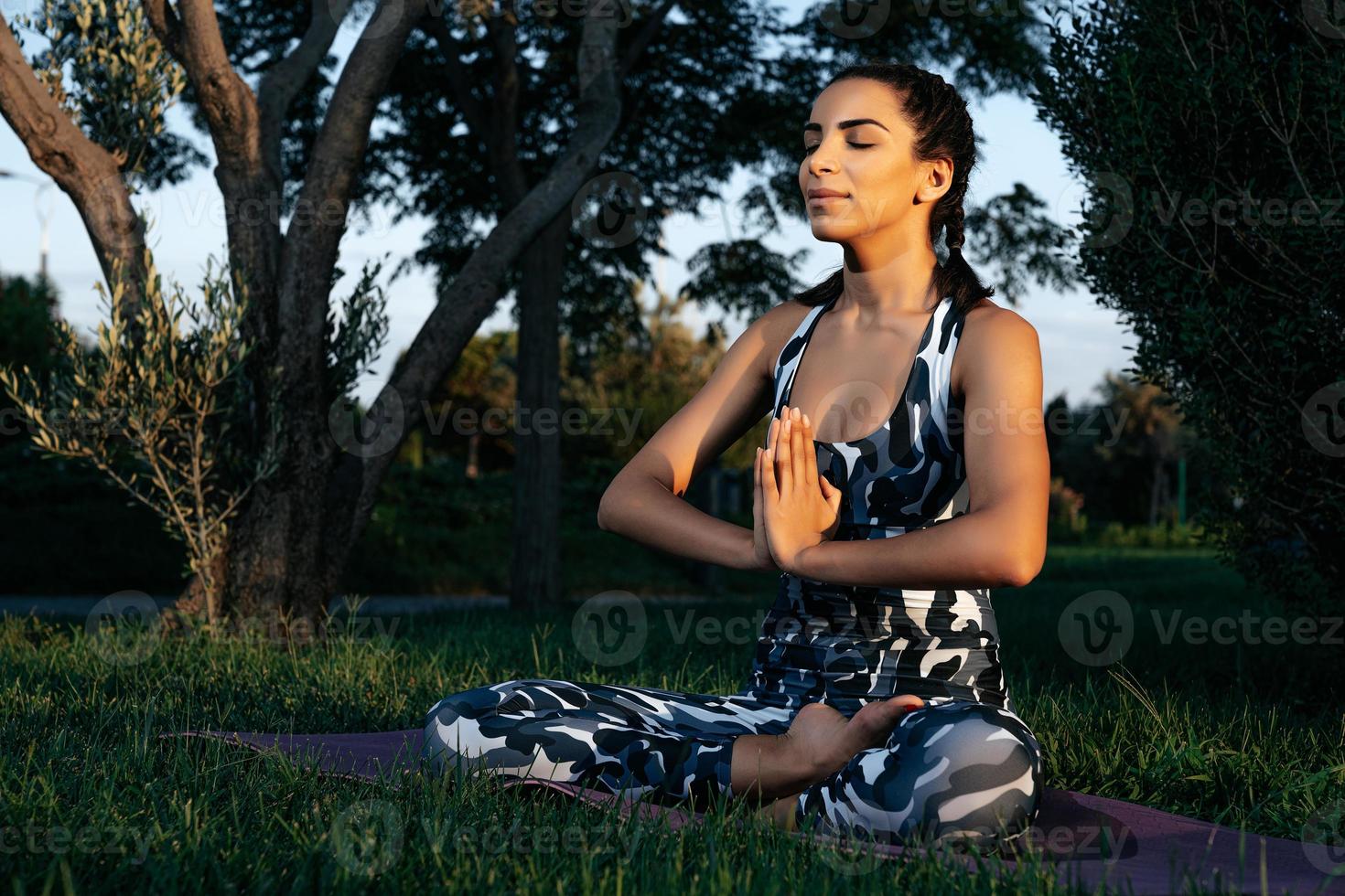 uma menina é acionado dentro ioga dentro natureza em uma filote esteira fechadas olhos foto