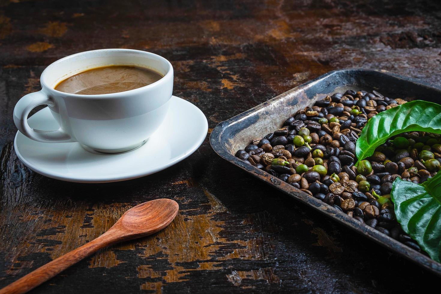 xícara de café e grãos de café em uma mesa de madeira foto