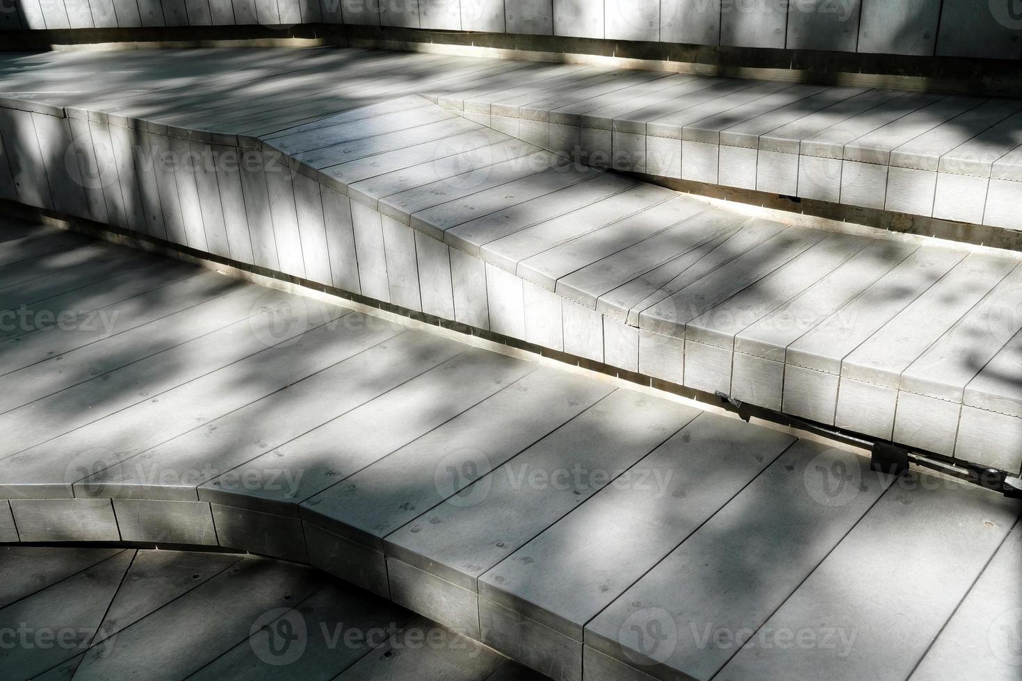 madeira Banco dentro a parque com luz e sombra em superfície. foto