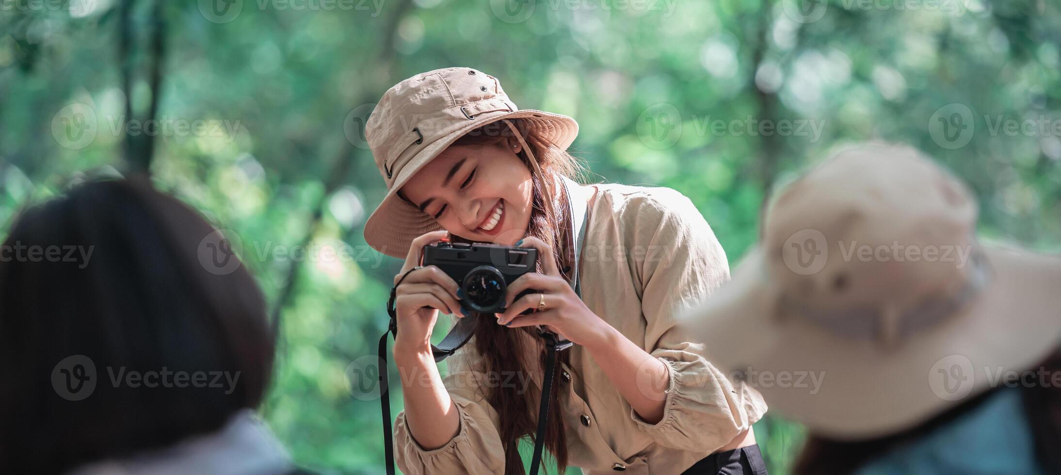 jovem mulher bonita usa a câmera tirando fotos de seus amigos