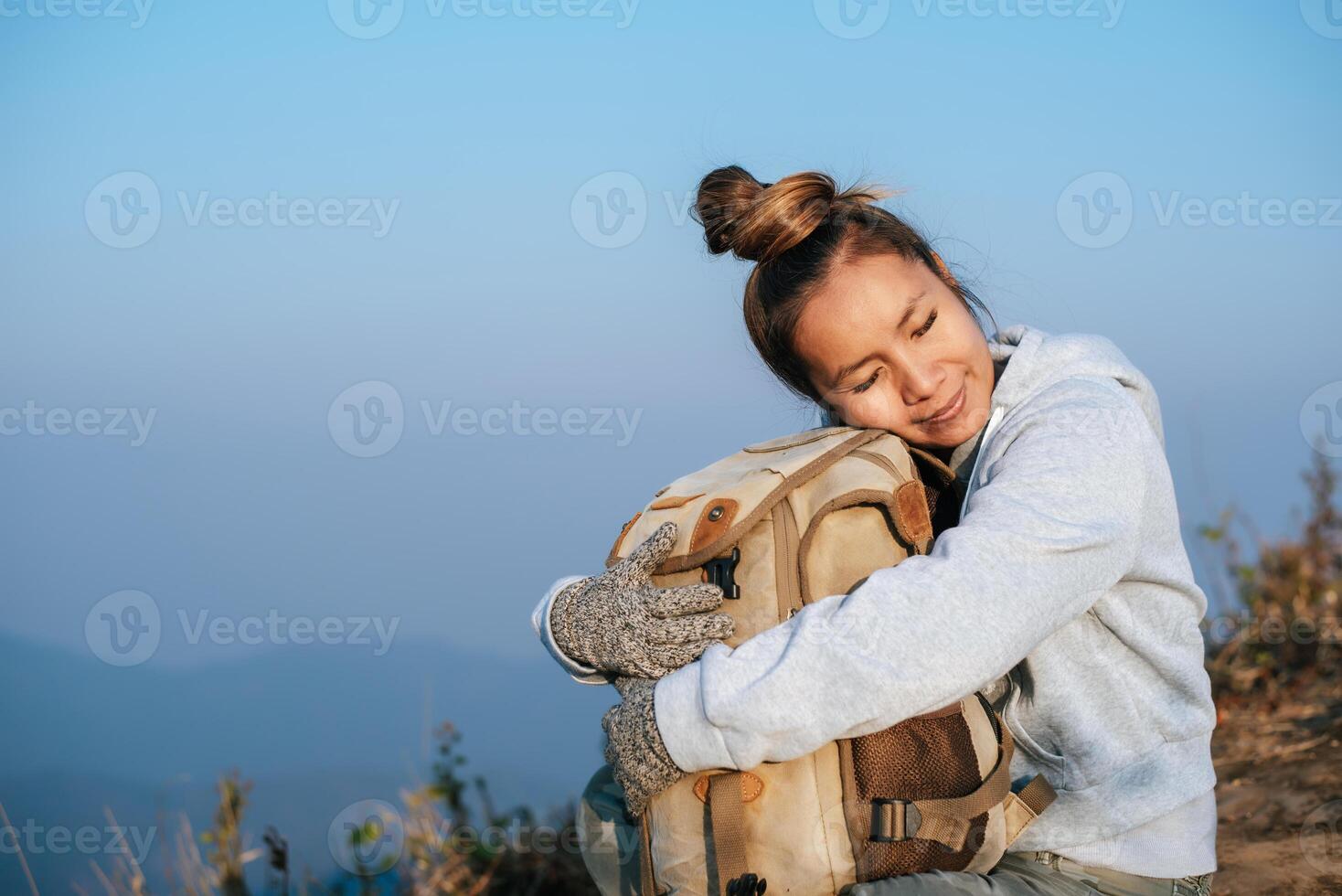 retrato do ásia caminhante mulher com mochila relaxante em montanha e desfrutando foto