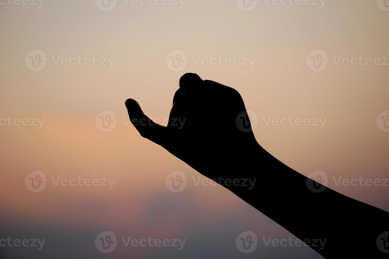 silhueta do uma humano mão fazer uma placa do reconciliação pôr do sol fundo foto