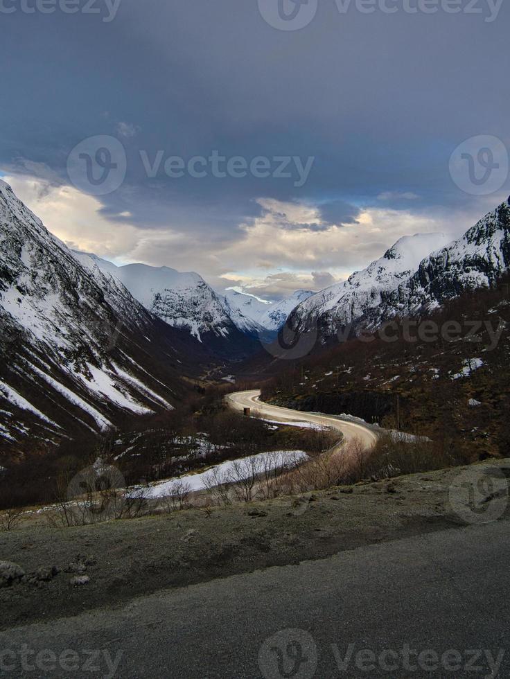 estrada sobre uma passagem na noruega, entre montanhas e neve foto