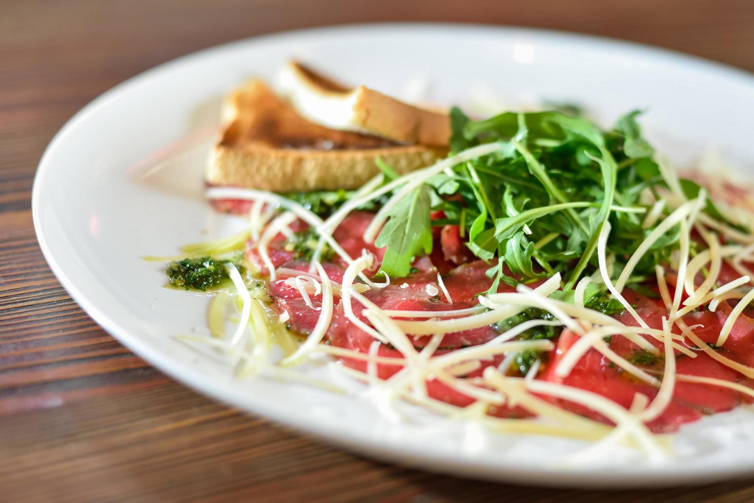 carpaccio com queijo parmesão no prato foto