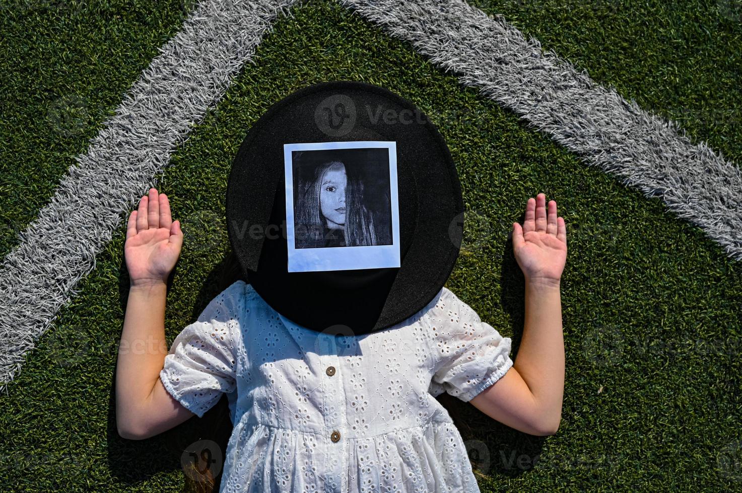 uma menina dentro uma branco vestir é deitado em a futebol campo. uma mulher dentro uma Preto chapéu mentiras em a artificial Relva em a Esportes campo. uma cansado jovem mulher é em repouso dentro a fresco ar. foto