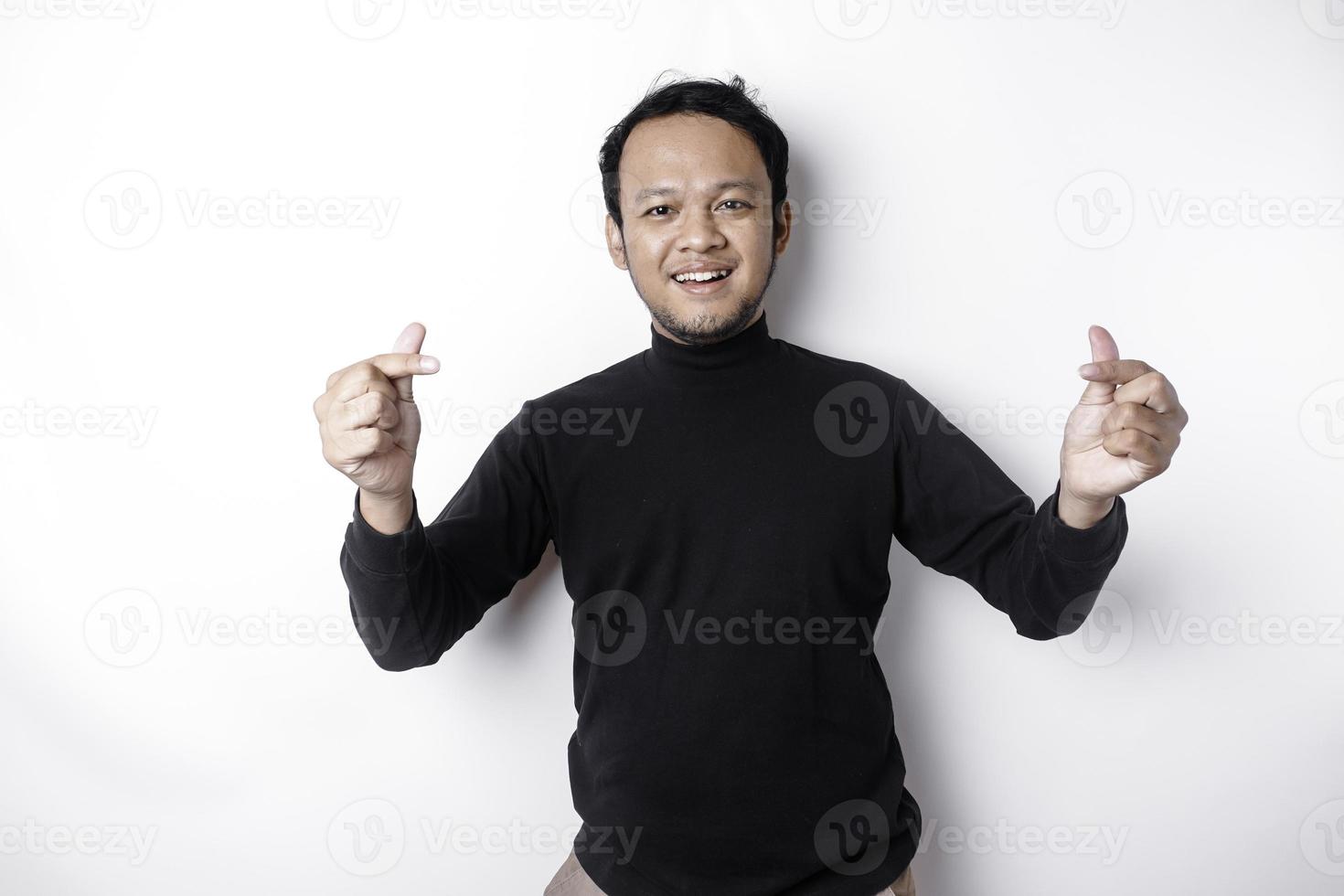 uma feliz jovem ásia homem vestindo uma Preto camisa sente romântico formas coração gesto expressando concurso sentimentos foto