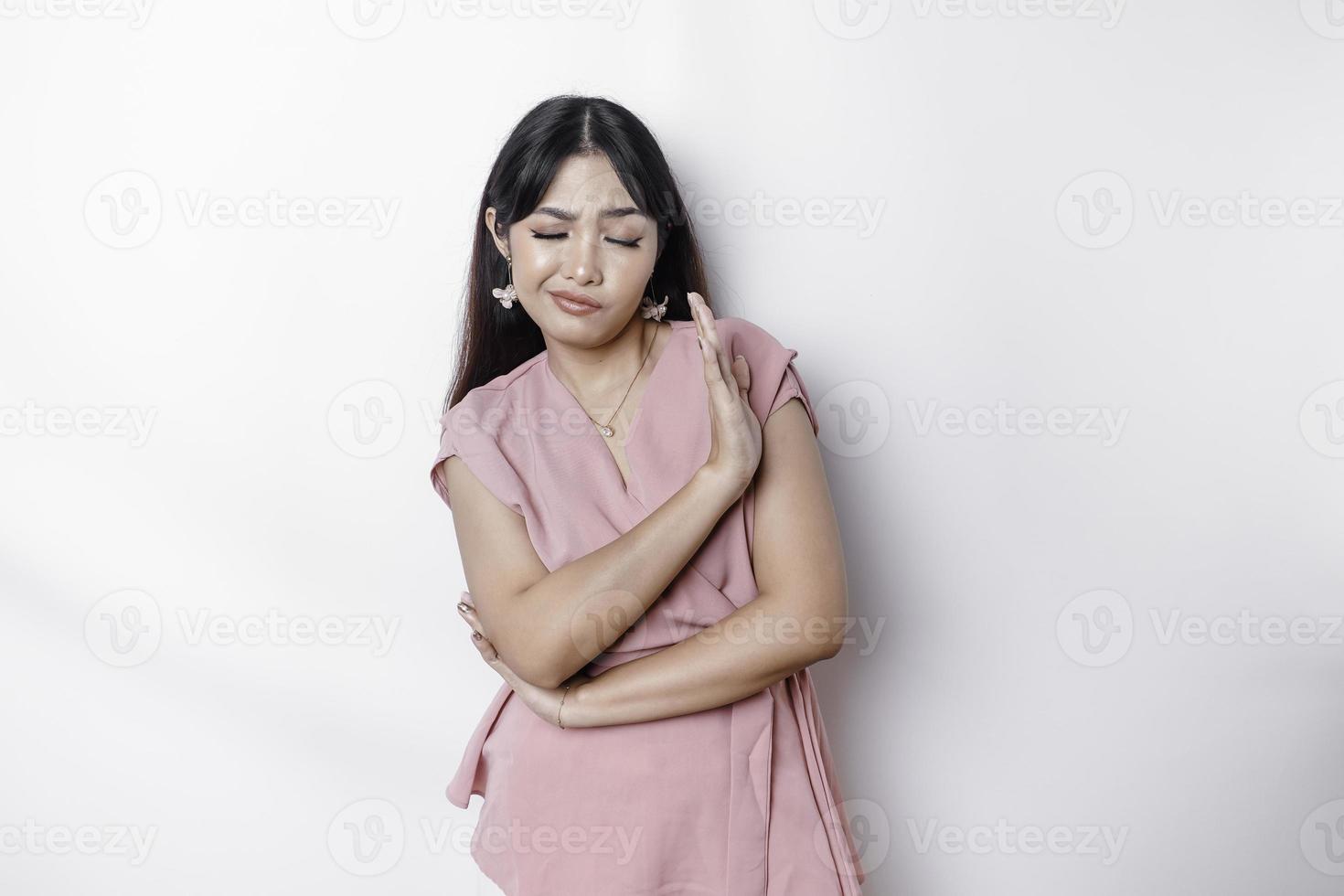 lindo ásia mulher vestindo Rosa blusa com mão gesto pose rejeição ou proibição com cópia de espaço foto