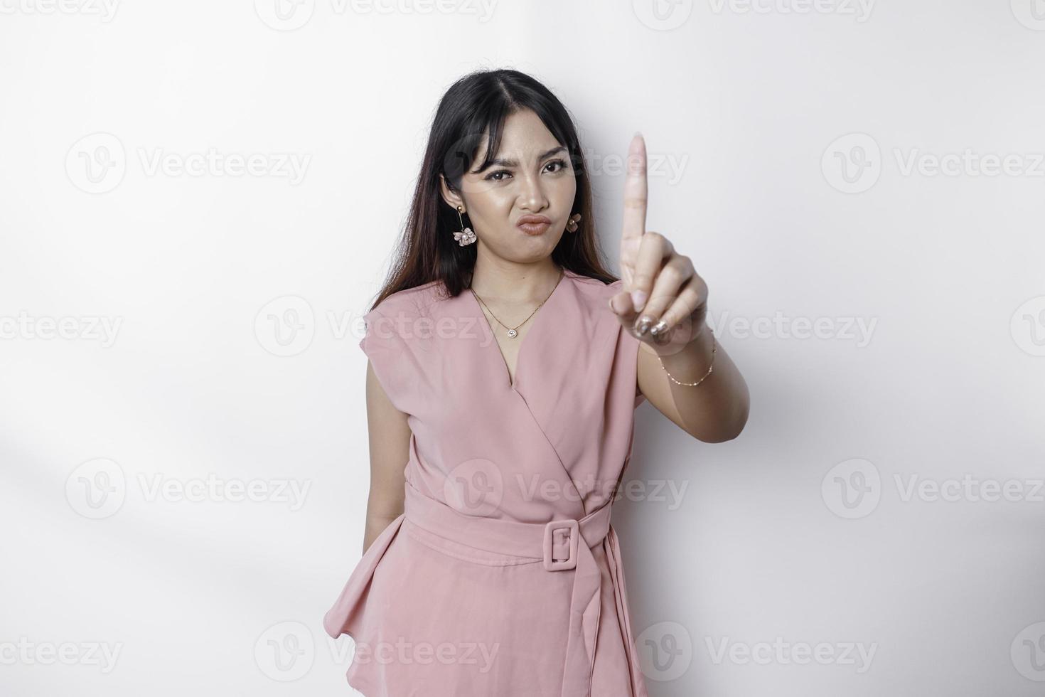 lindo ásia mulher vestindo Rosa blusa com mão gesto pose rejeição ou proibição com cópia de espaço foto