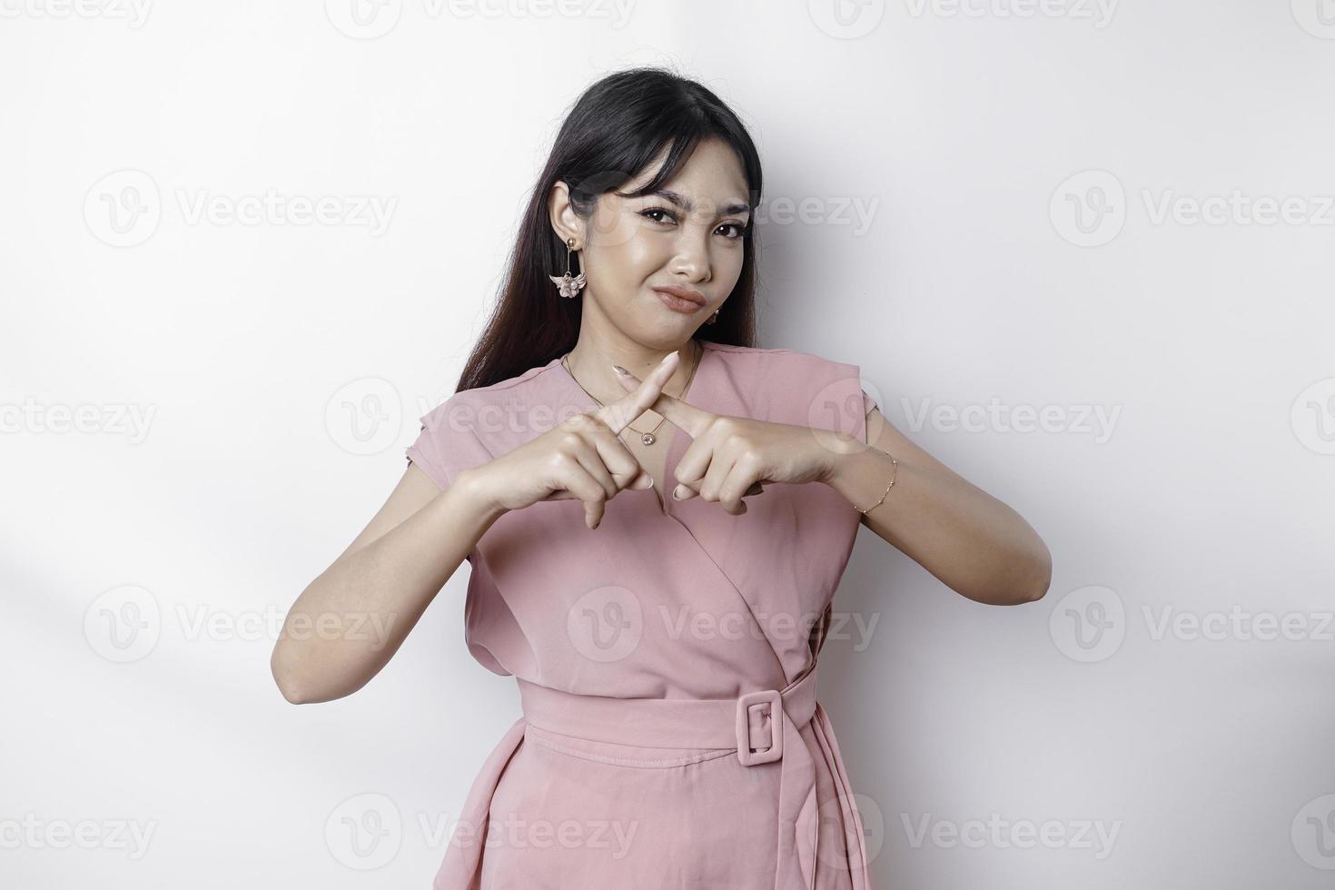 lindo ásia mulher vestindo Rosa blusa com mão gesto pose rejeição ou proibição com cópia de espaço foto