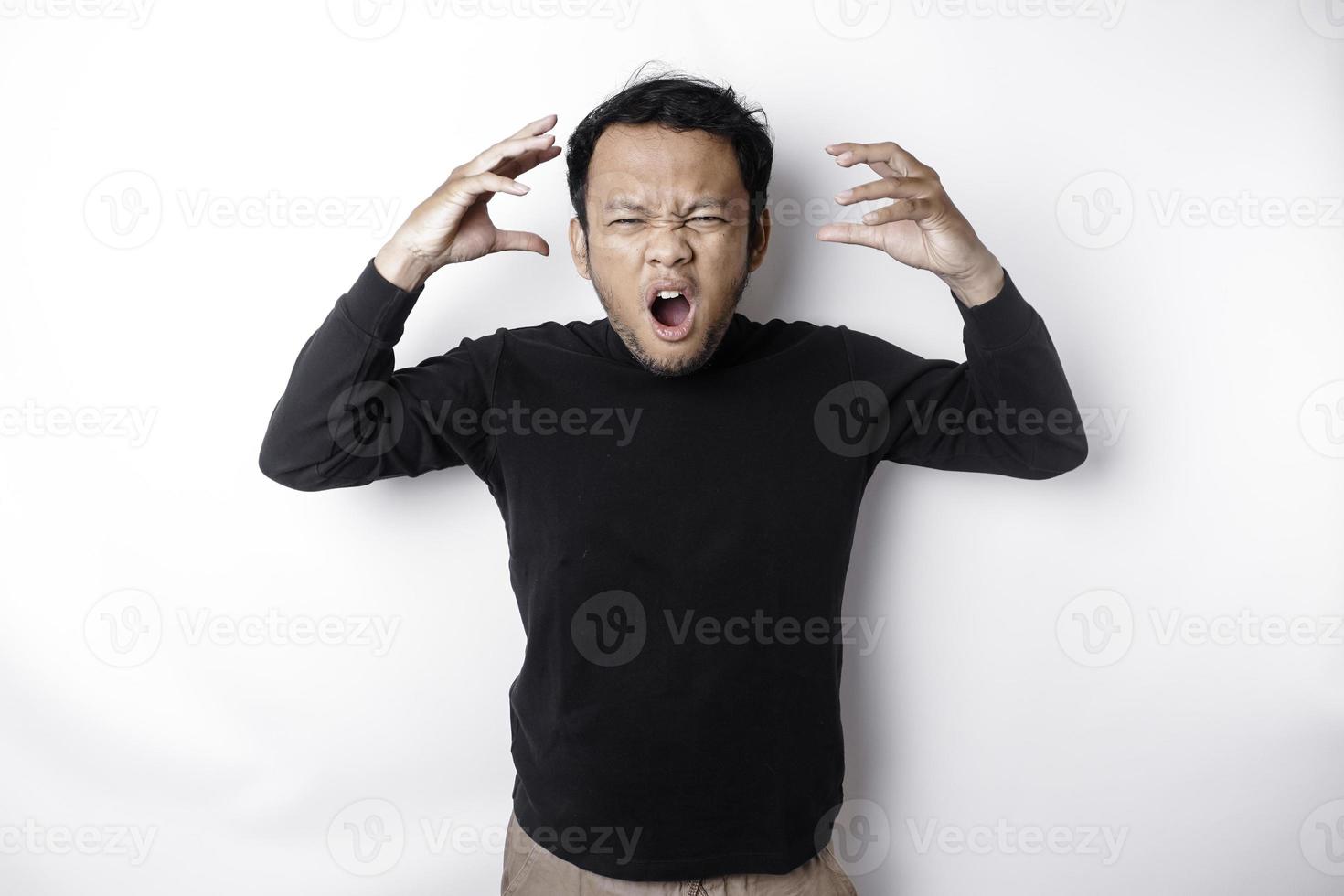 a Bravo e louco face do ásia homem dentro Preto camisa isolado branco fundo. foto