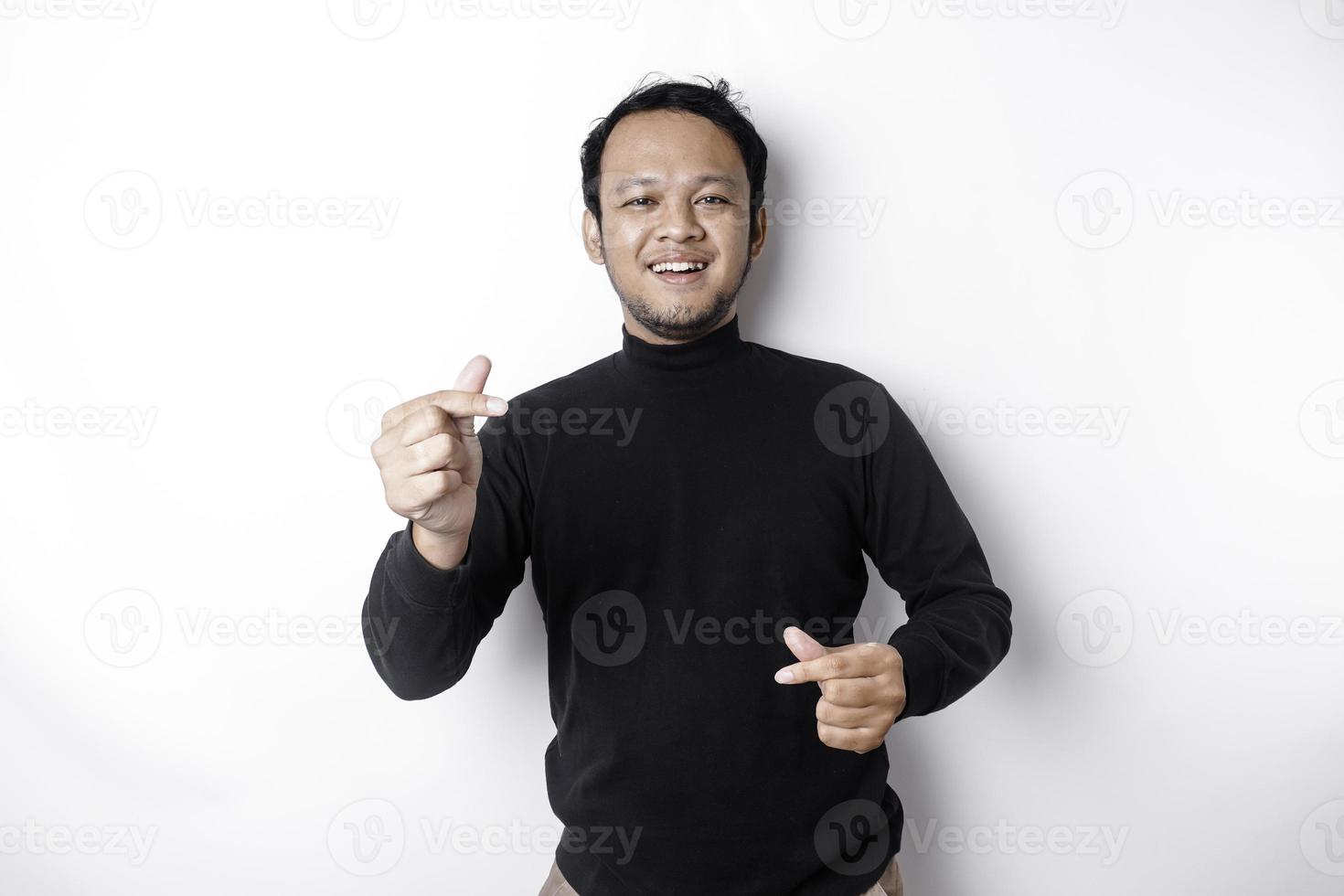 uma feliz jovem ásia homem vestindo uma Preto camisa sente romântico formas coração gesto expressando concurso sentimentos foto