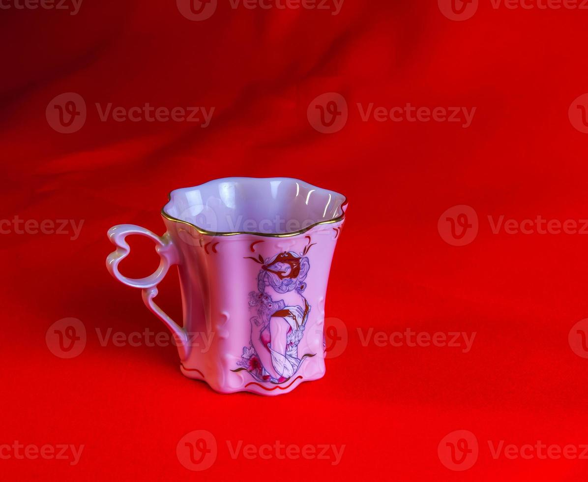 porcelana Rosa copo do a incomum forma é fez dentro a tcheco república. uma copo com uma romântico padronizar em uma vermelho fundo. foto