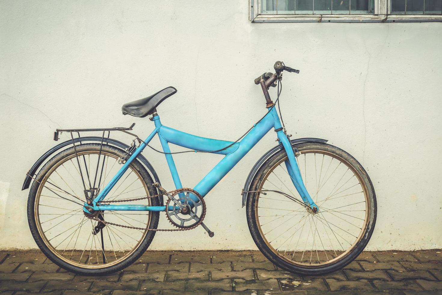 bicicleta inclinado contra a velho gesso parede casa foto