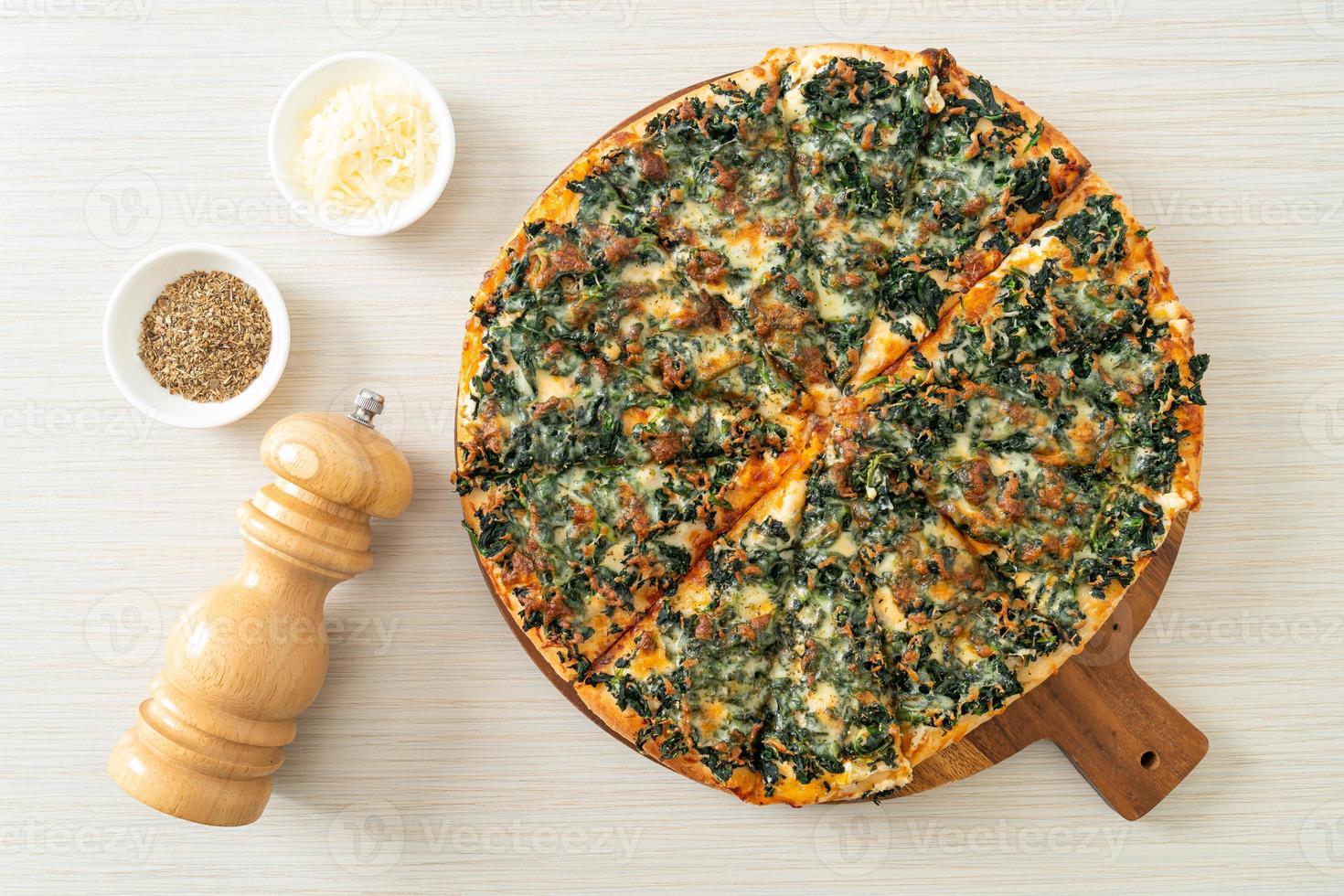 Pizza de espinafre e queijo na bandeja de madeira foto