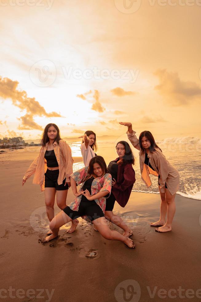 uma grupo do indonésio mulheres apreciar a de praia alegremente quando elas Conheça seus amigos às a feriado momento foto