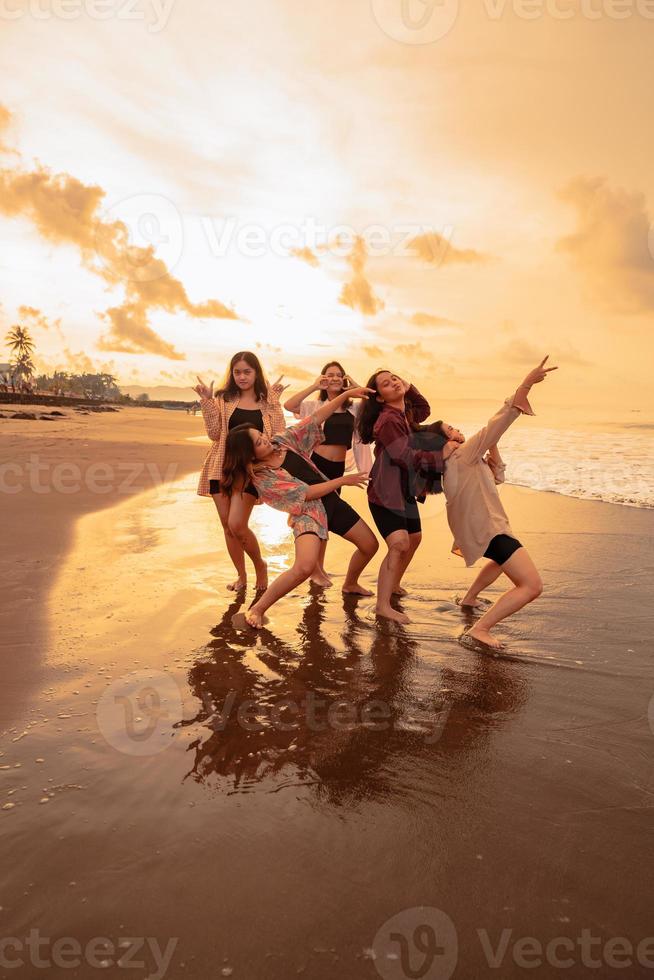 uma grupo do indonésio mulheres apreciar a de praia alegremente quando elas Conheça seus amigos às a feriado momento foto