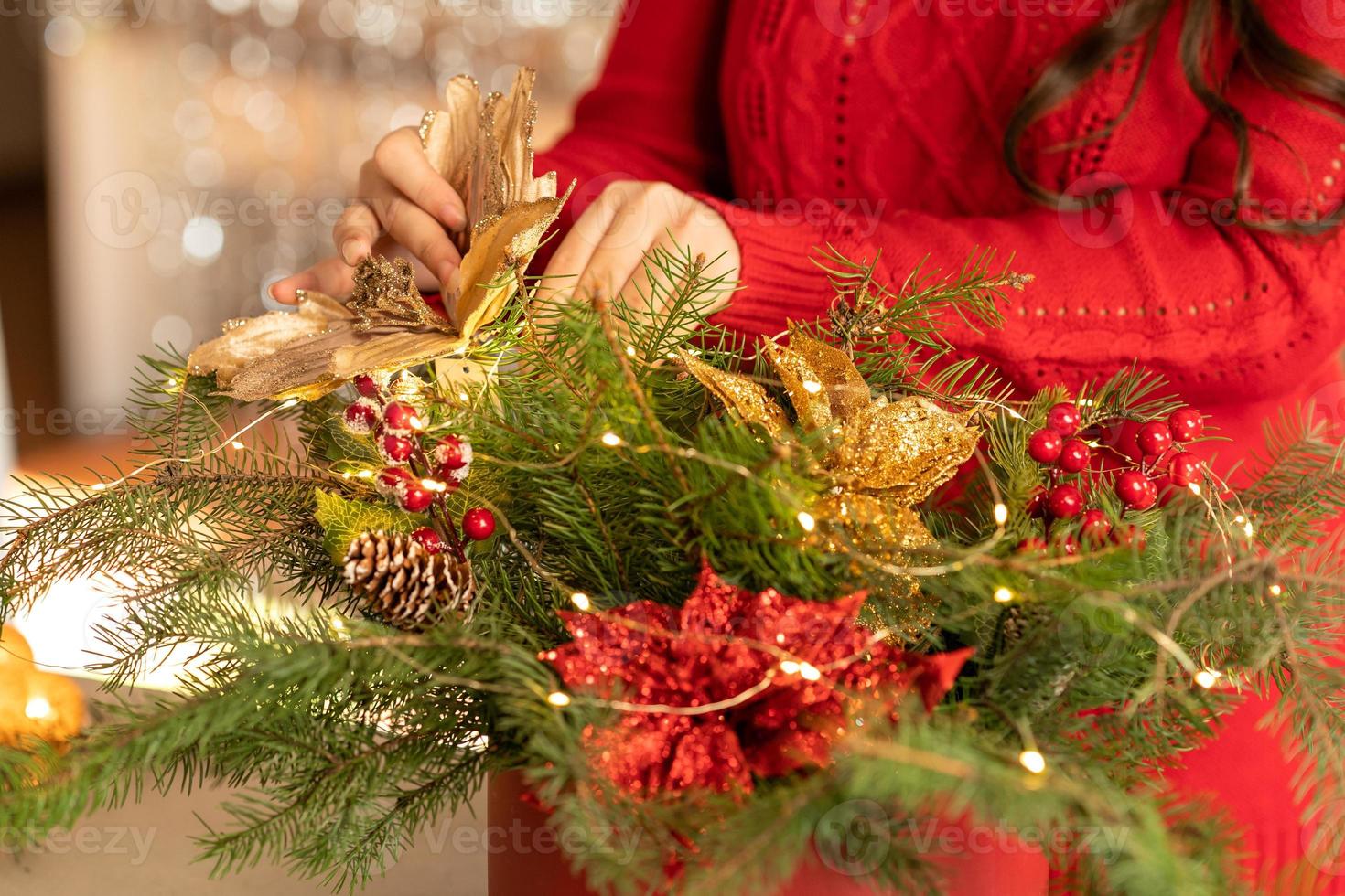 menina recolhe um buquê de natal de ramos de abeto, flores e enfeites de árvore de natal foto