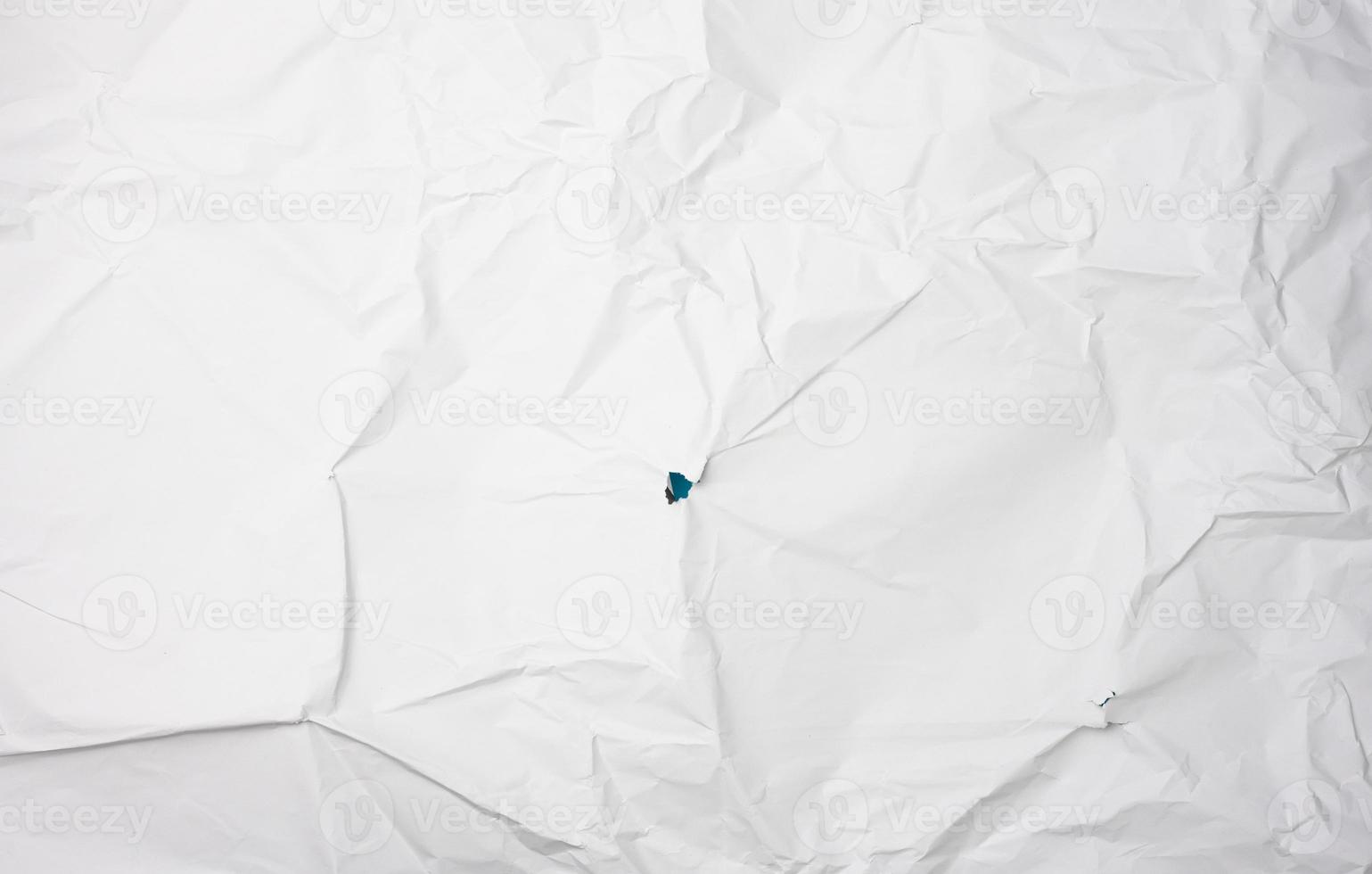 papel branco amassado, vincos e um buraco foto