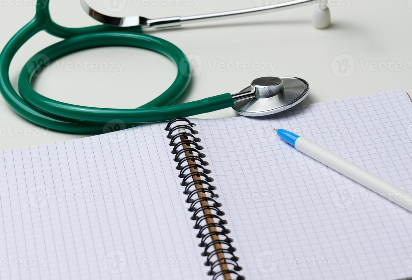 aberto em branco caderno com caneta e estetoscópio, branco mesa foto