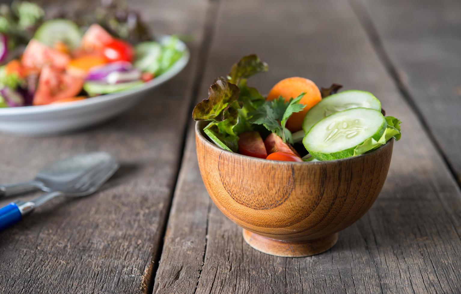 salada de legumes fresca em fundo de madeira foto