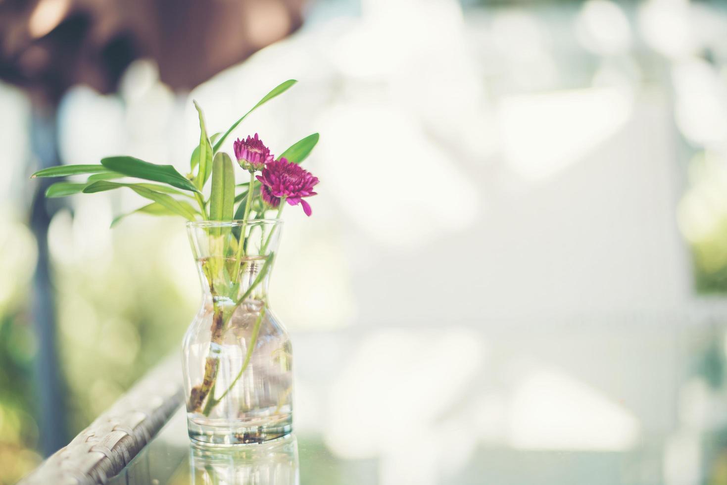 flores roxas em um vaso em uma mesa ao ar livre foto