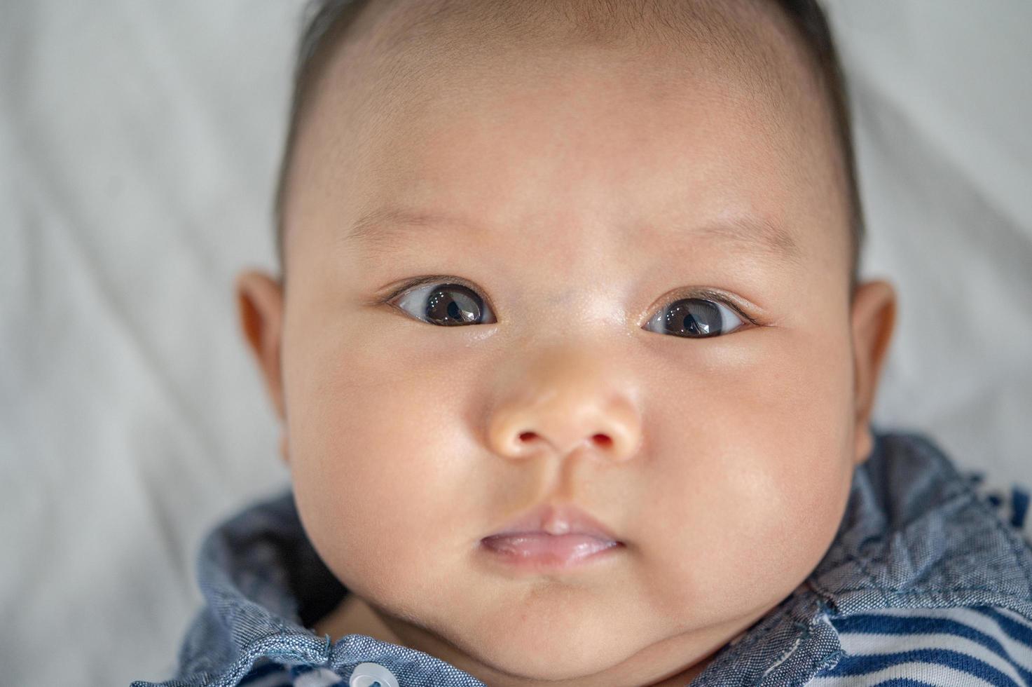 um bebê recém-nascido que abre os olhos e olha para a frente foto