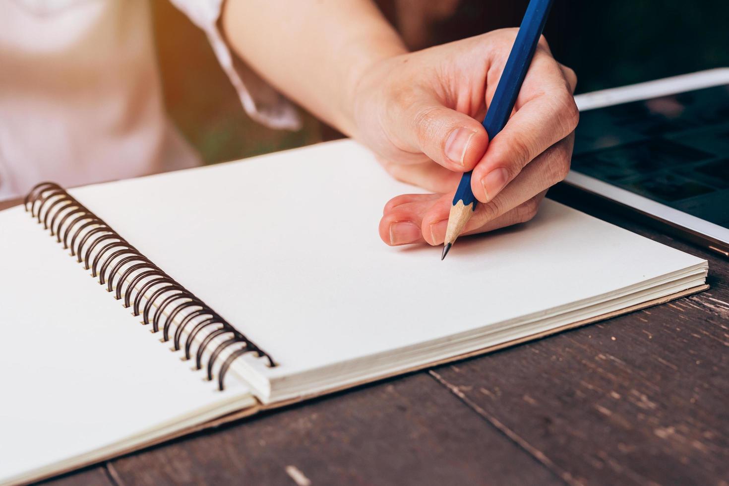ásia mulher mão escrevendo lápis em caderno dentro café fazer compras com vintage tonificado foto