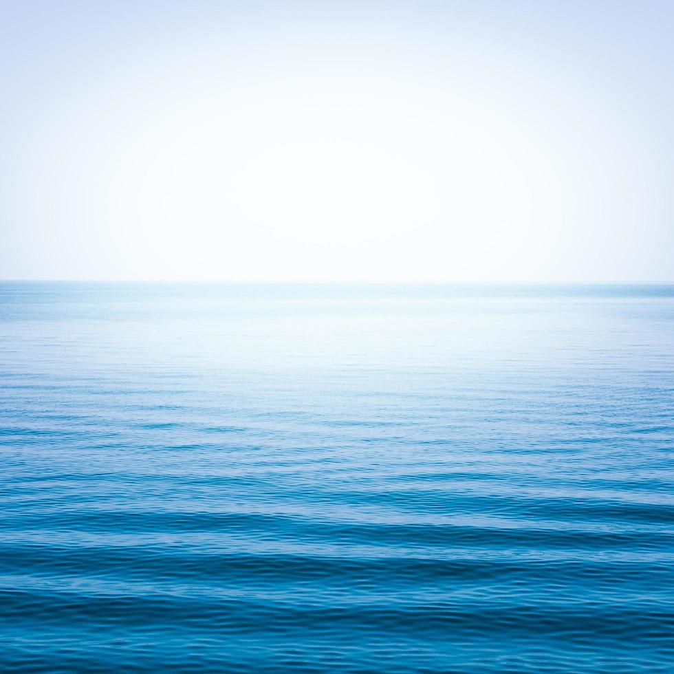 mar azul com ondas e céu azul claro foto