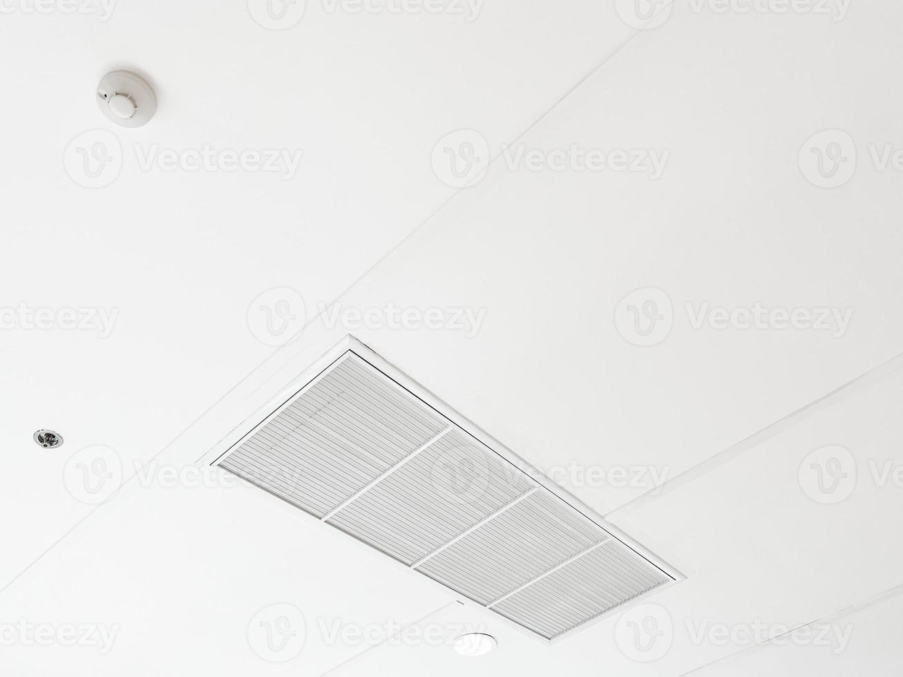 condicionador de ar tipo cassete montado no teto e luz de lâmpada moderna no teto branco. ar condicionado de duto para casa ou escritório foto