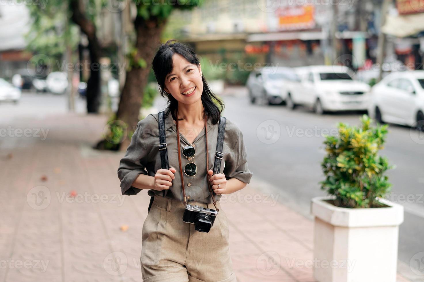 jovem ásia mulher mochila viajante desfrutando rua cultural local Lugar, colocar e sorriso. foto