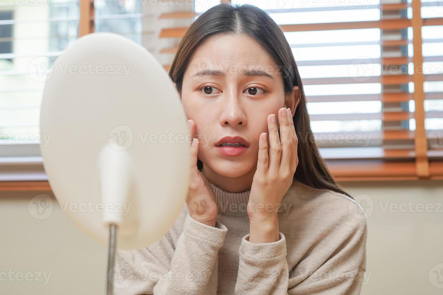 dermatologia, puberdade ásia jovem mulher, menina olhando para dentro espelho, alergia apresentando a alérgico reação a partir de Cosmético, vermelho local ou erupção cutânea em face. beleza Cuidado a partir de pele problema de médico tratamento. foto