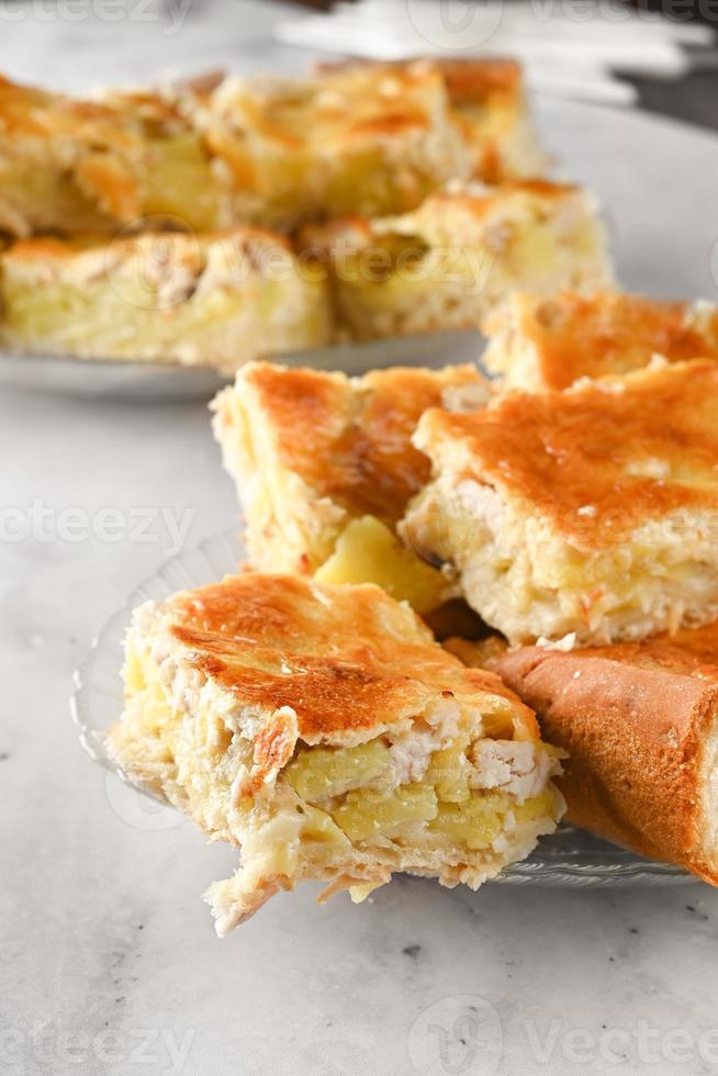 prato do frango e batata torta em luz fundo. parte do caseiro torta em uma branco prato em uma luz mesa foto