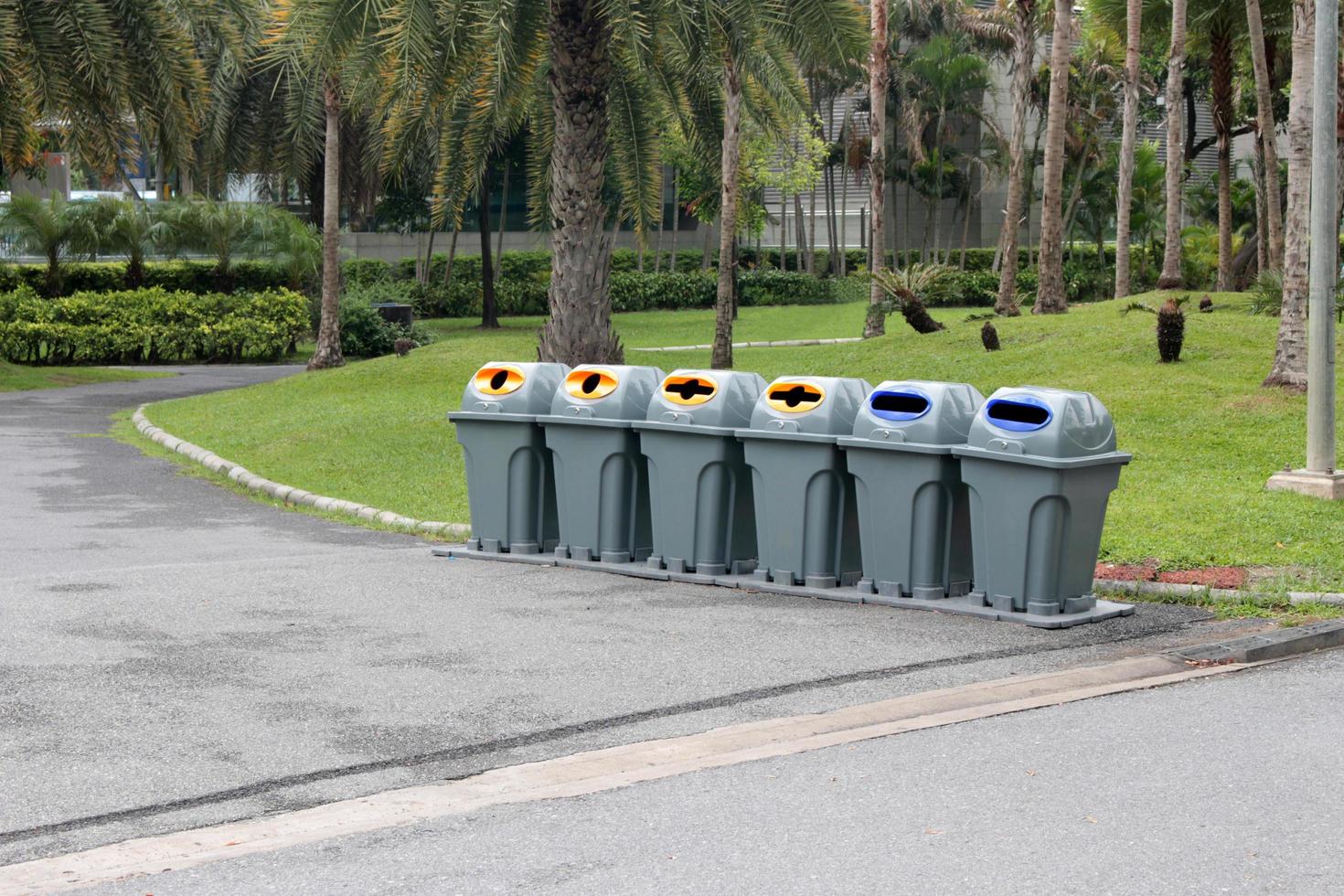 fila de latas de lixo em um parque foto