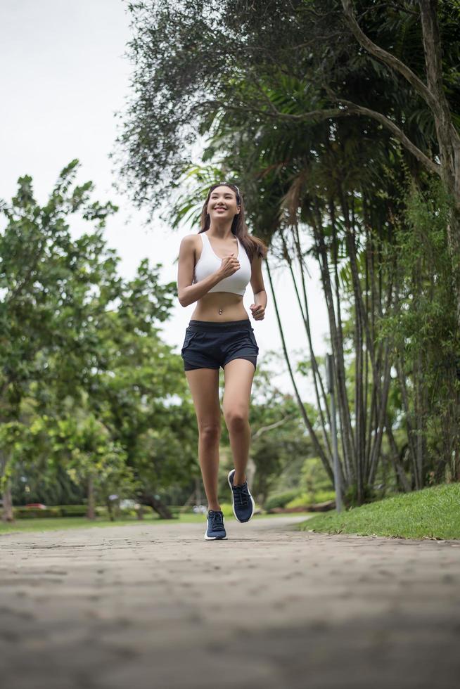 jovem desportiva correndo no parque foto