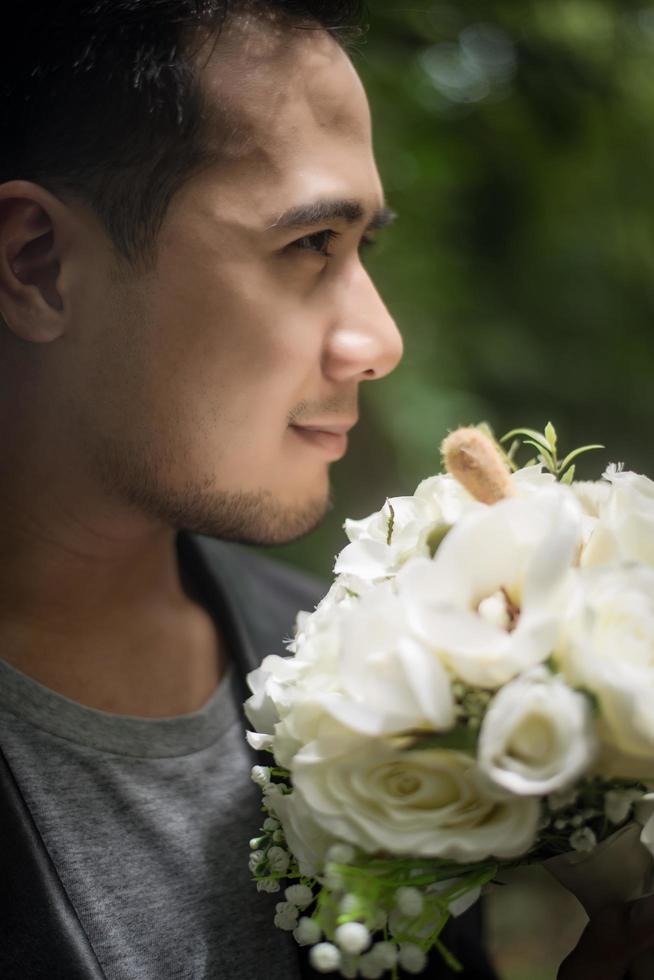 close-up do noivo com lindo buquê nas mãos para a noiva foto