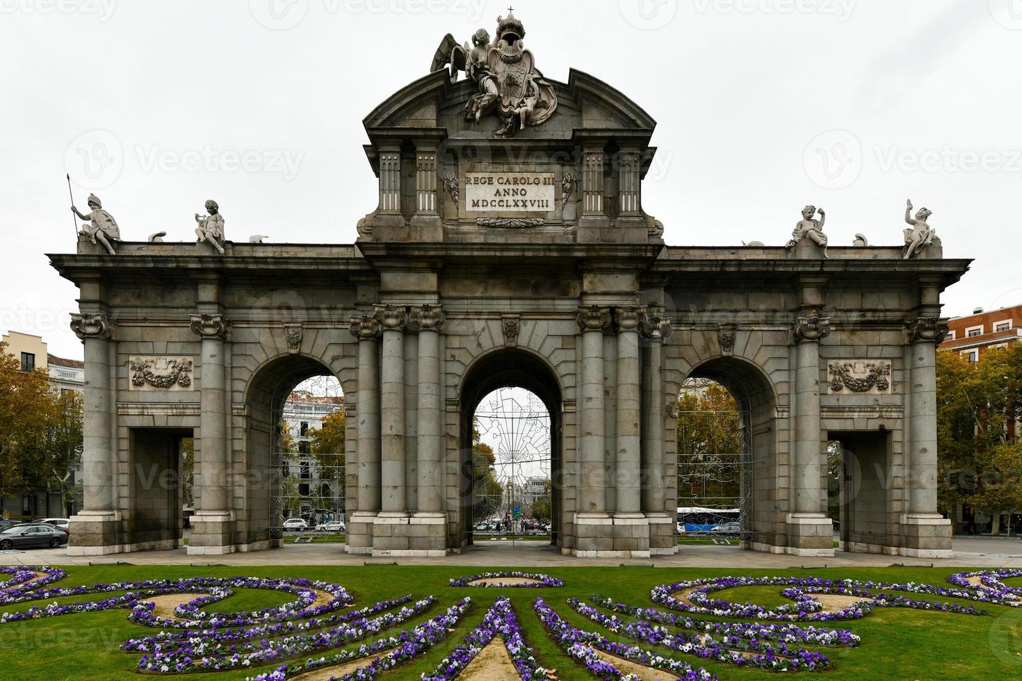 puerta de alcala, uma neoclássico portão dentro a praça de la independência dentro madri, Espanha. inscrição rei Charles iii. foto