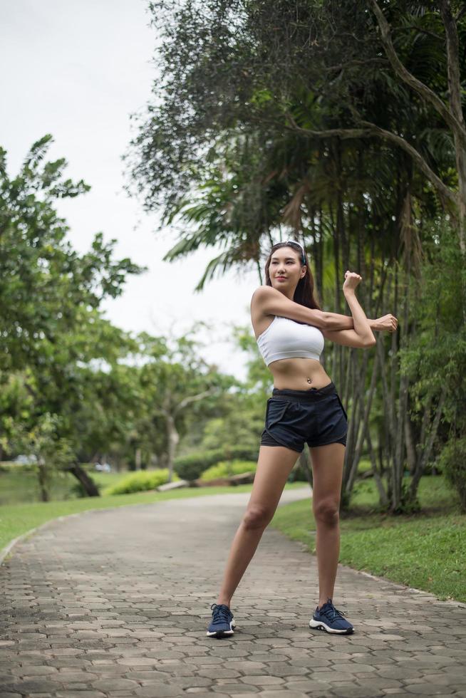 jovem desportiva alongando-se no parque foto