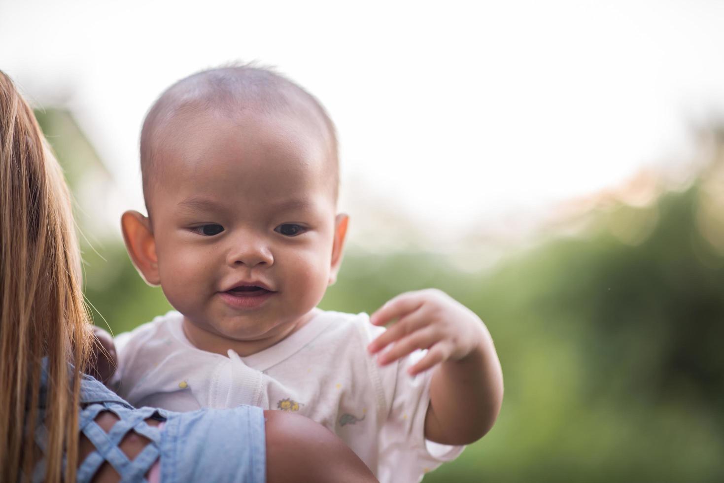 mãe e bebê rindo e brincando no parque foto